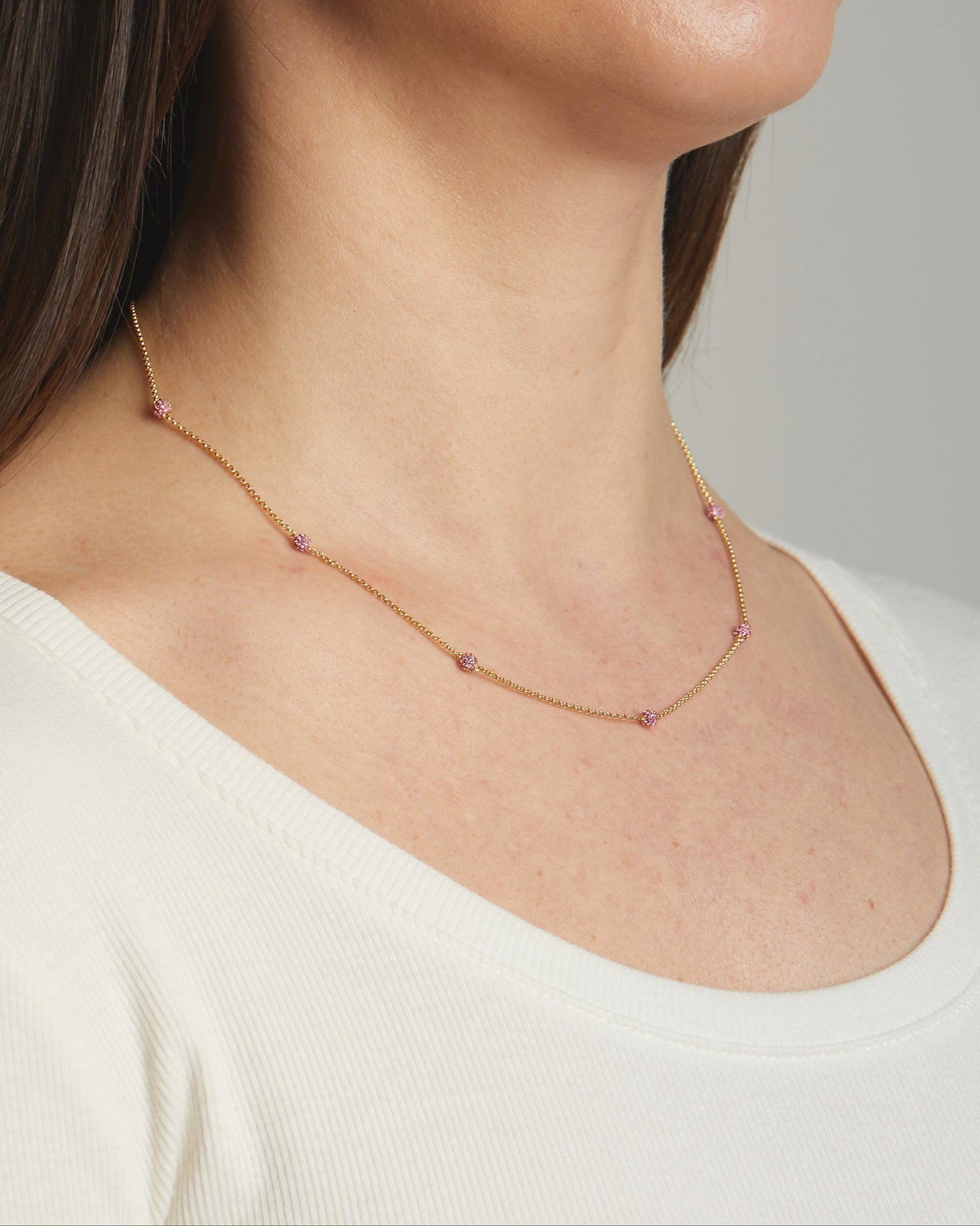 Model wearing ruby gold birthstone beaded necklace.