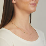 Model wearing emerald gemstone beaded necklace. 