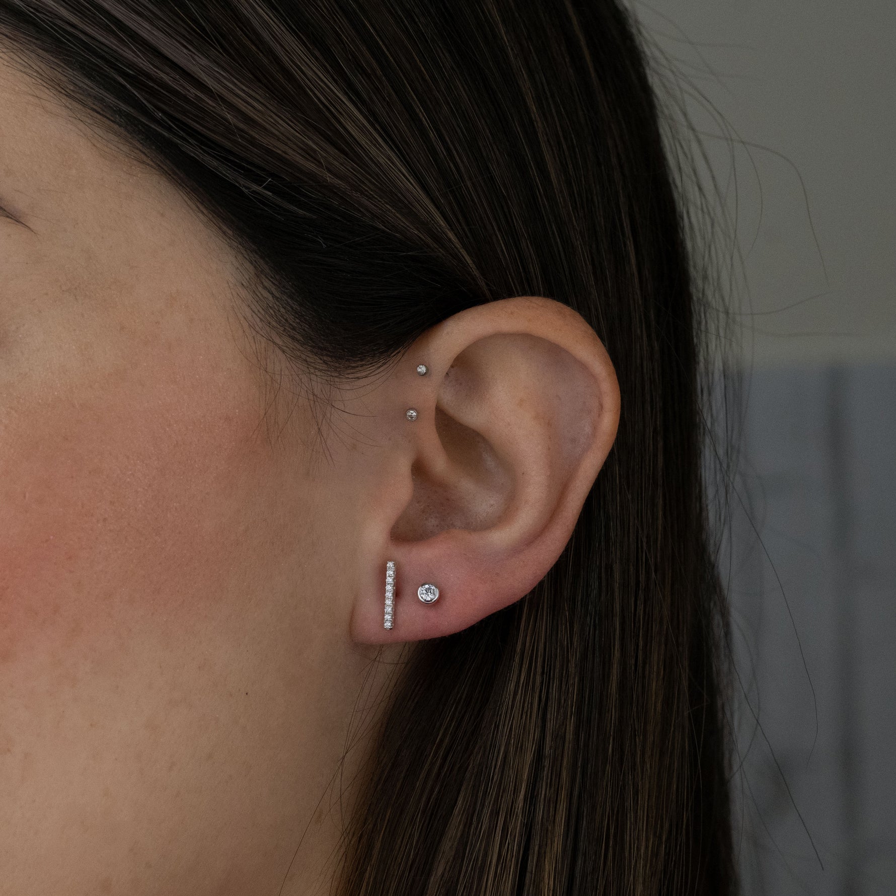 Dainty sterling silver bar stud earrings paired with round diamond stud earrings. 