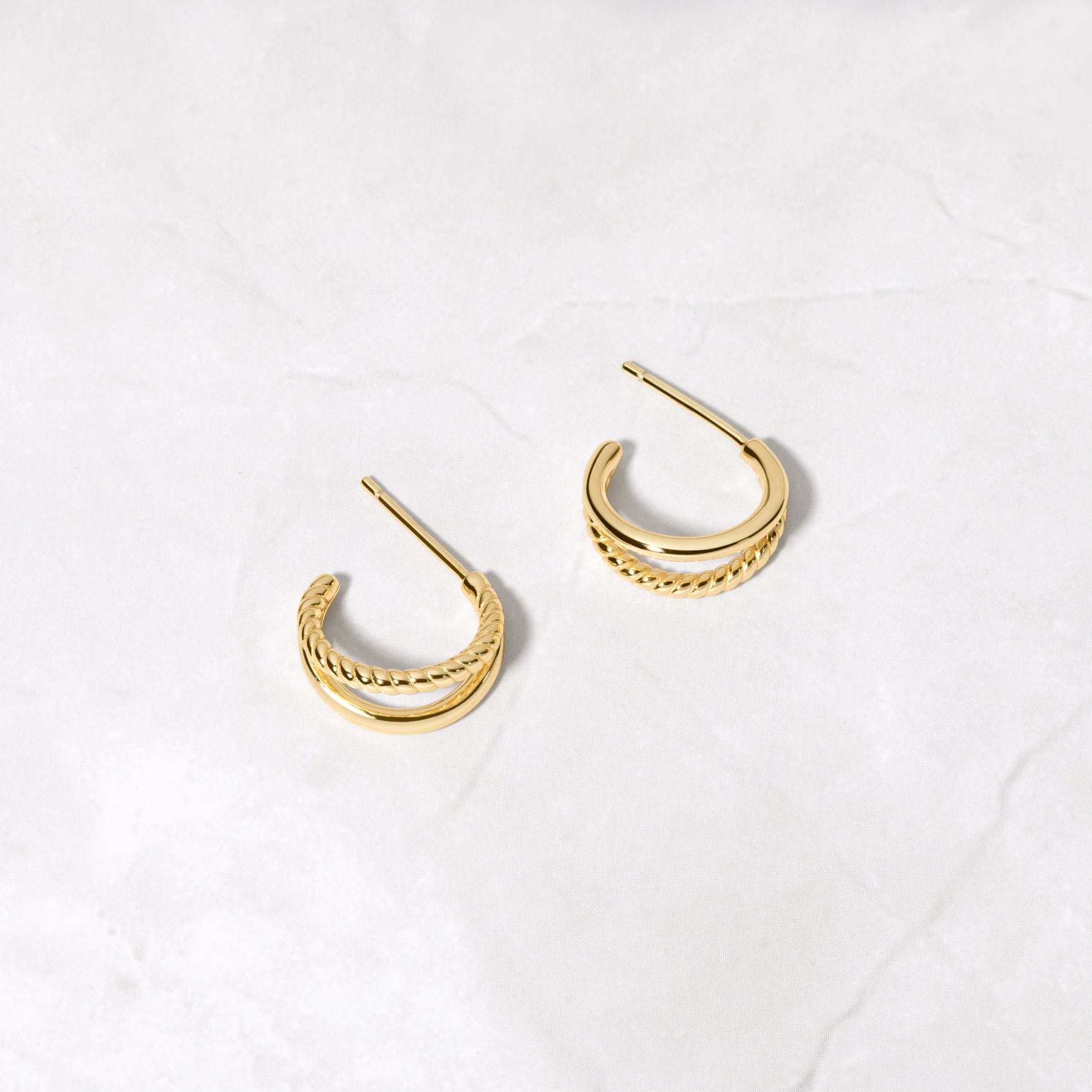 Tiny gold hoop earrings from the side. 