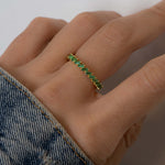 Model wearing gold slanted emerald baguette ring.