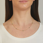 Model wearing emerald ball beaded necklace. 