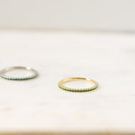 Delicate gold cz eternity birthstone ring in soft studio lighting.