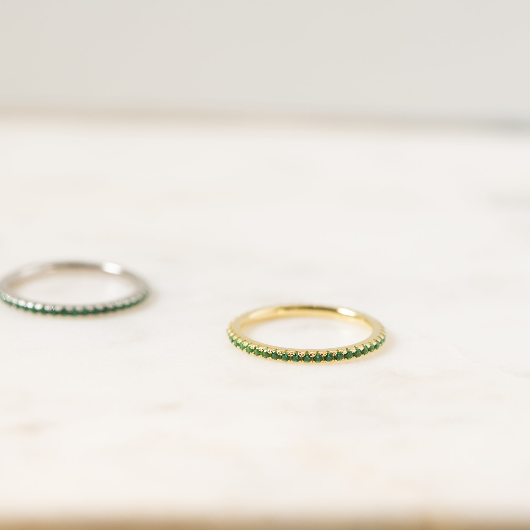 Delicate gold cz eternity birthstone ring in soft studio lighting.