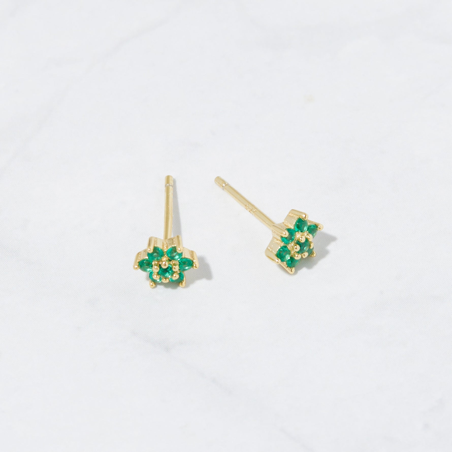 Emerald flower stud earrings from the above angle with gold post. 