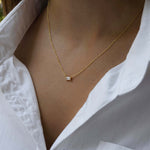 Model wearing gold baguette dainty chain necklace. 