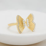 Upclose shot of large gold adjustable butterfly ring. 