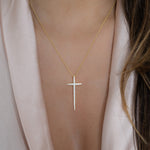 Model wearing large cz gold cross pendant necklace.