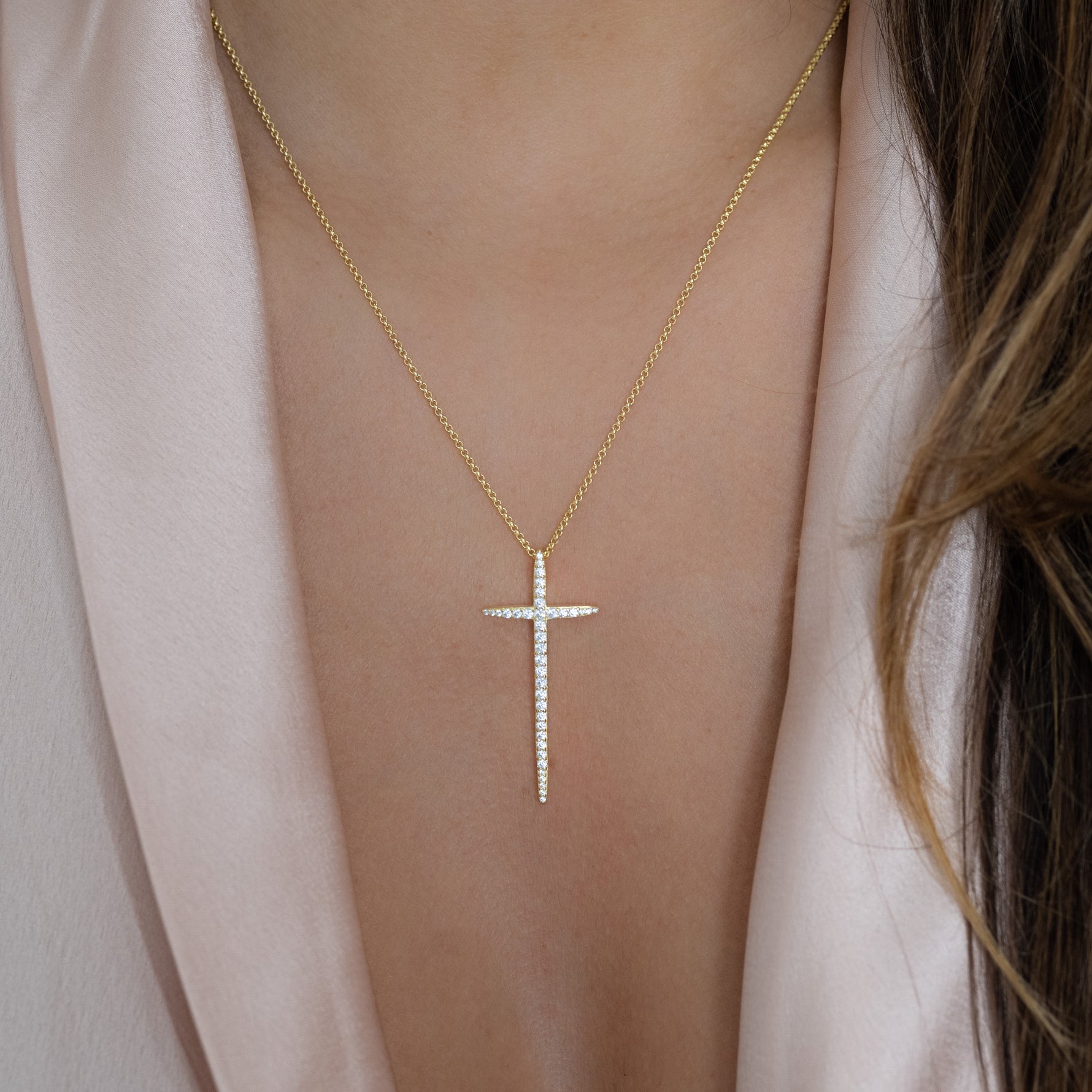 Model wearing large cz gold cross pendant necklace.