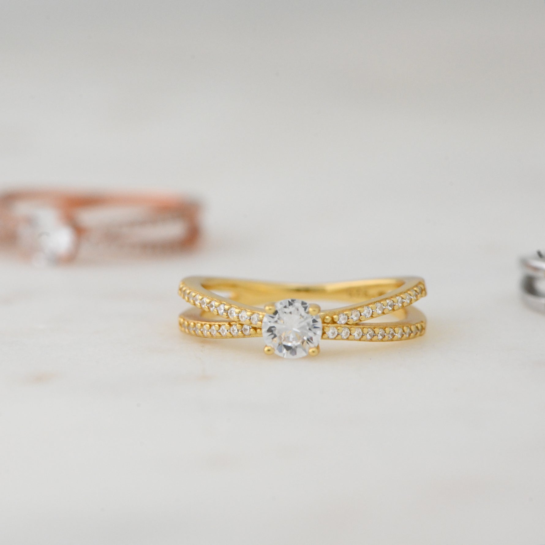 Upclose image of gold diamond double shank solitaire ring. 