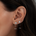 Model wearing round diamond gold stud earrings in 6mm and 5mm, paired with a classic gold ball stud. 