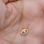 Gold evil eye pendant necklace close-up.