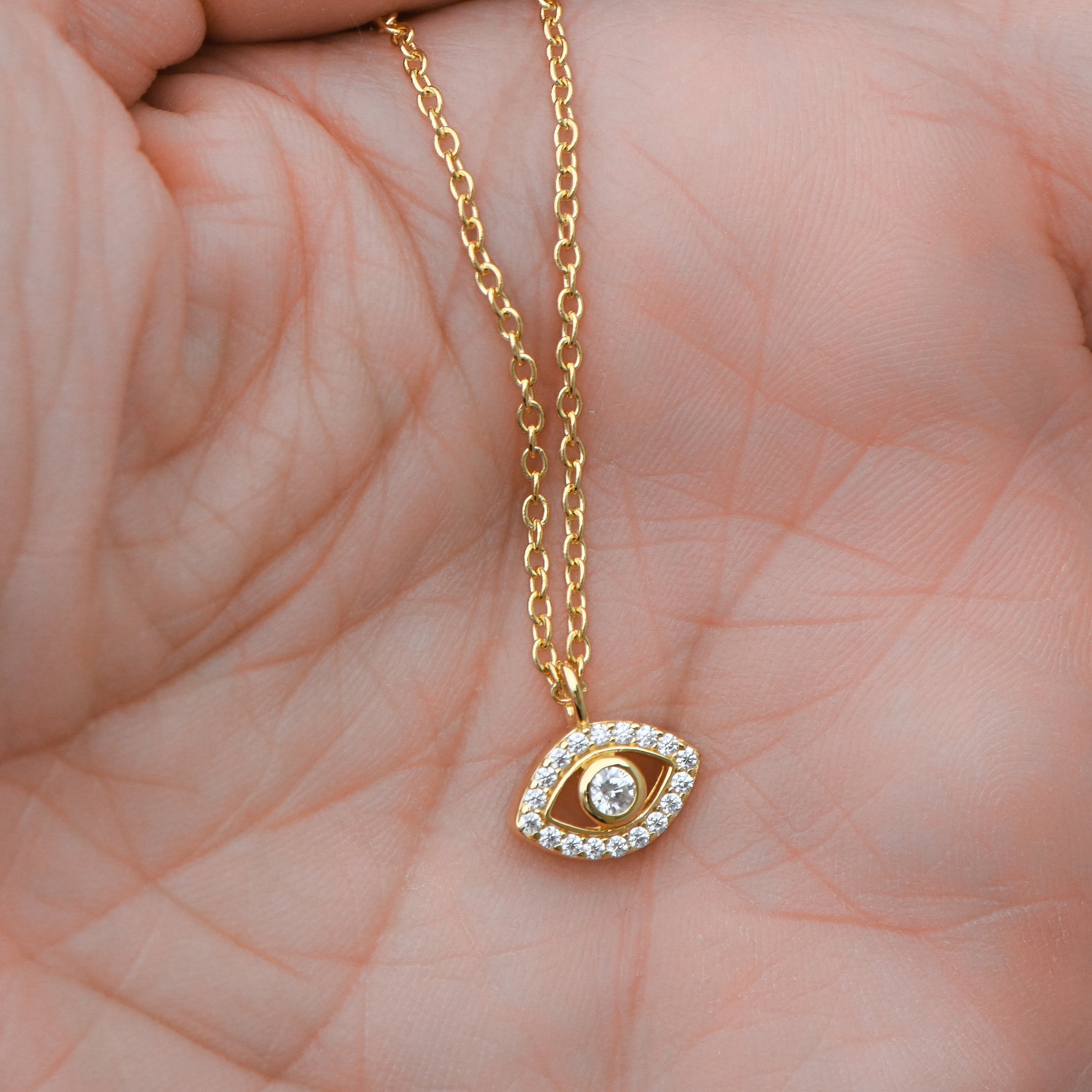 Gold evil eye pendant necklace close-up.