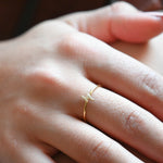 Upclose shot of model wearing dainty gold lightning bolt ring. 