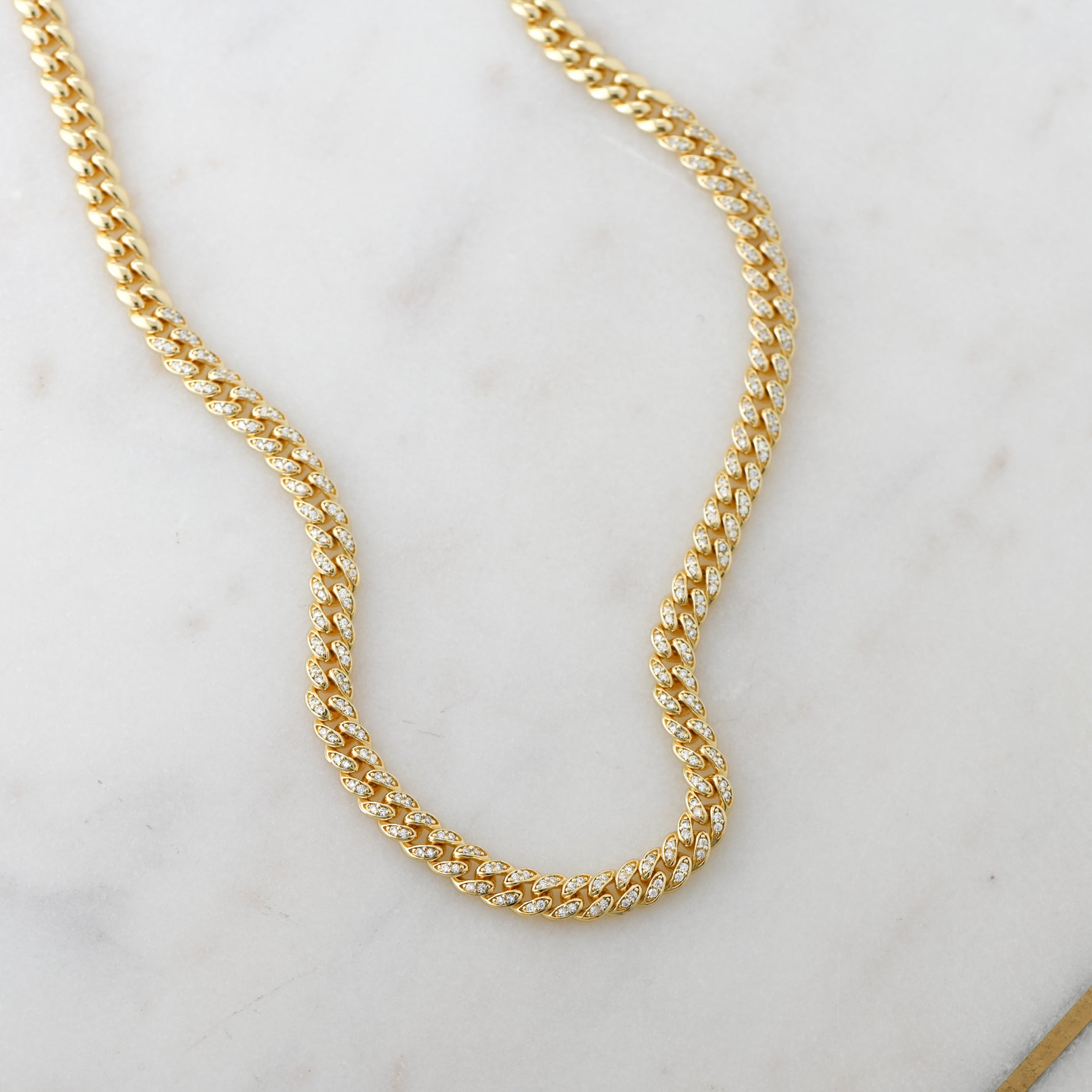 Gold cuban link chain necklace with cz stones throughout.