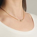 Model wearing minimalist gold baguette bezel pendant necklace on chain.
