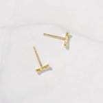 Small gold moon stud earrings with a gold post.