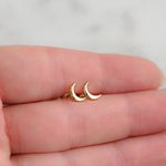 Model holding delicate gold plain moon stud earrings