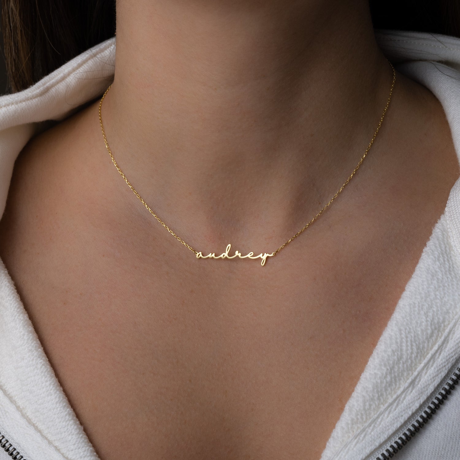 Model wearing gold custom script name necklace with a dainty chain 