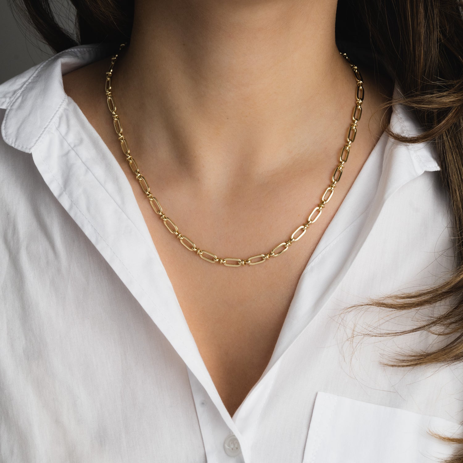Model wearing gold chain link necklace.