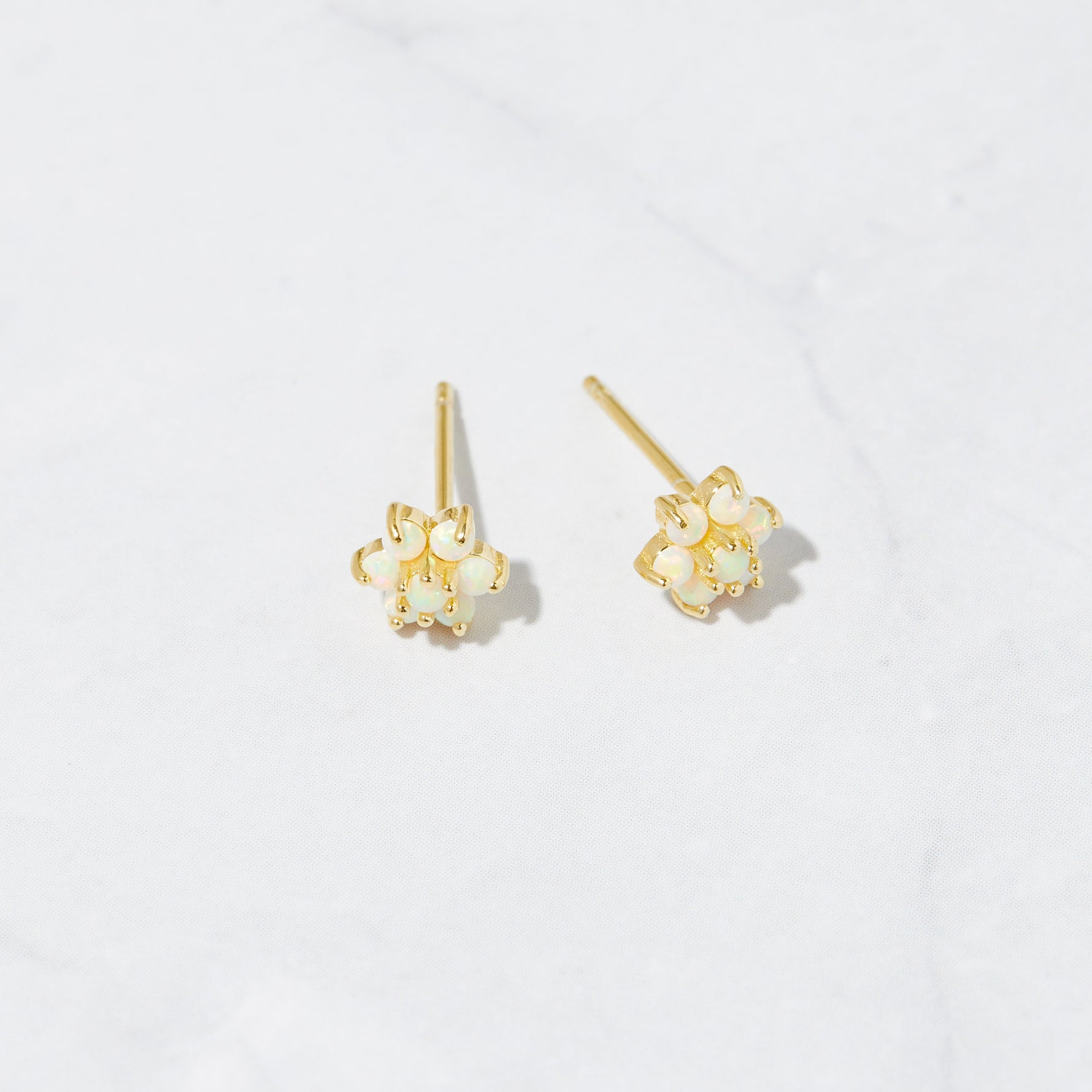 Gold opal birthstone stud earrings from the top angle.