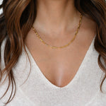 Model wearing minimalist gold paperclip chain necklace.