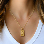 Model wearing gold rectangle rose medallion necklace.