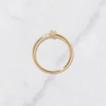 Dainty gold pear stone ring in gold on marble background. 