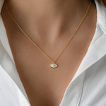 Model wearing delicate gold chain with opal evil eye necklace.
