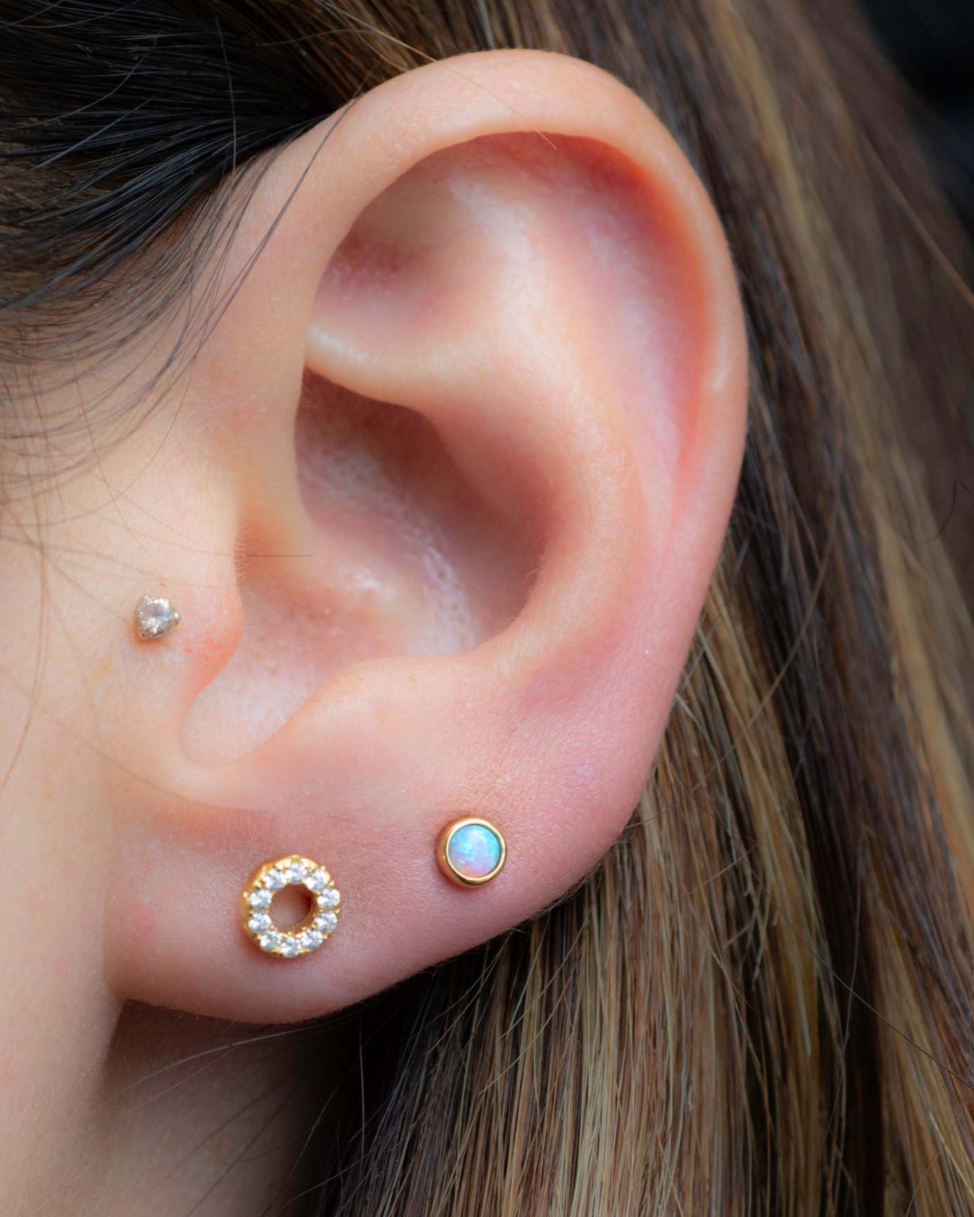 Model wearing gold opal and cz round stud earrings.