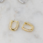 Upclose shot of gold pavé dainty huggie earrings.
