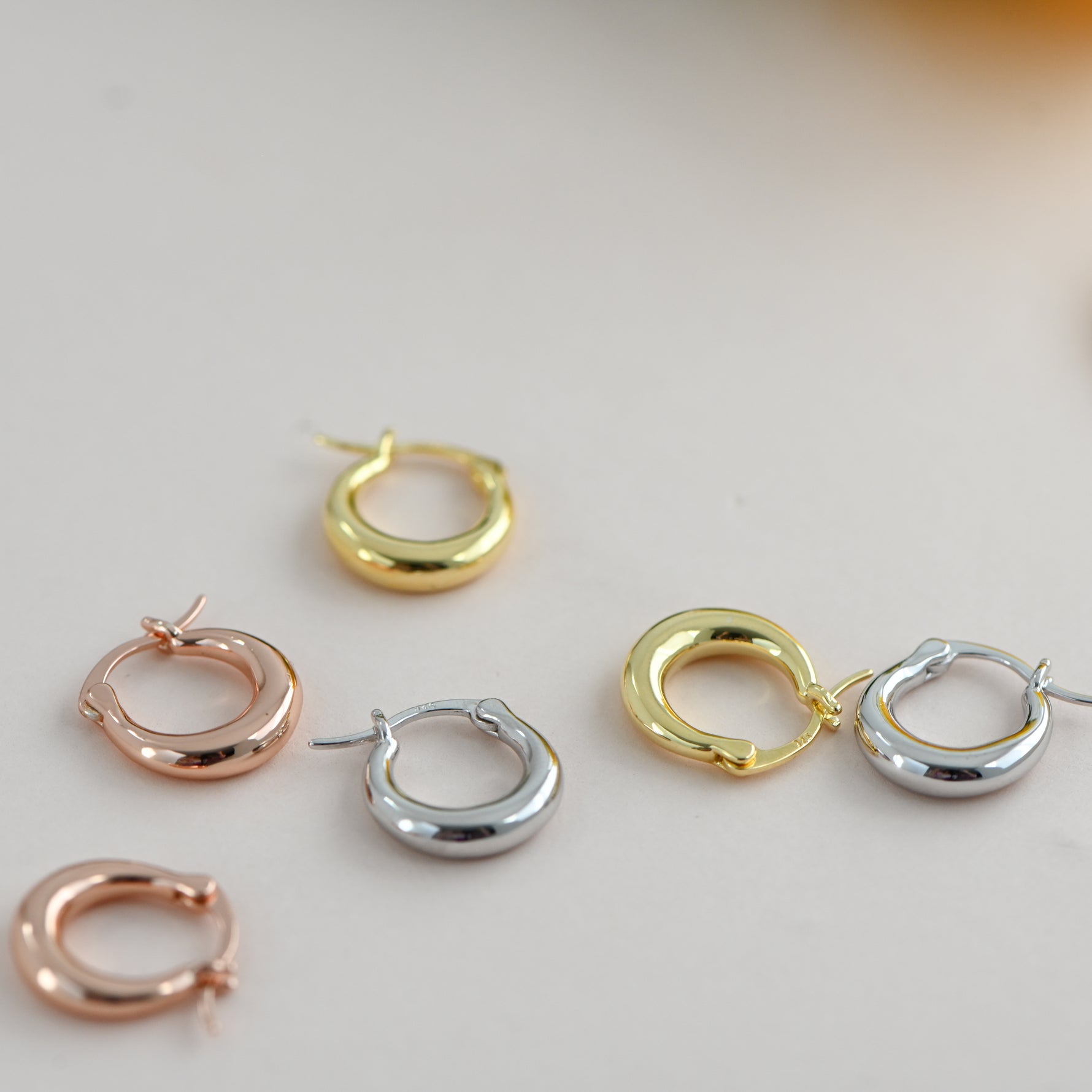 Round mini basket huggies in rose gold, sterling silver, and gold. 