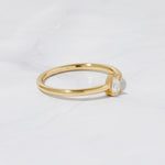 Dainty gold stacking ring on marble background. 