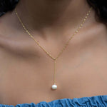 Model wearing classy and elegant gold pearl lariat necklace.