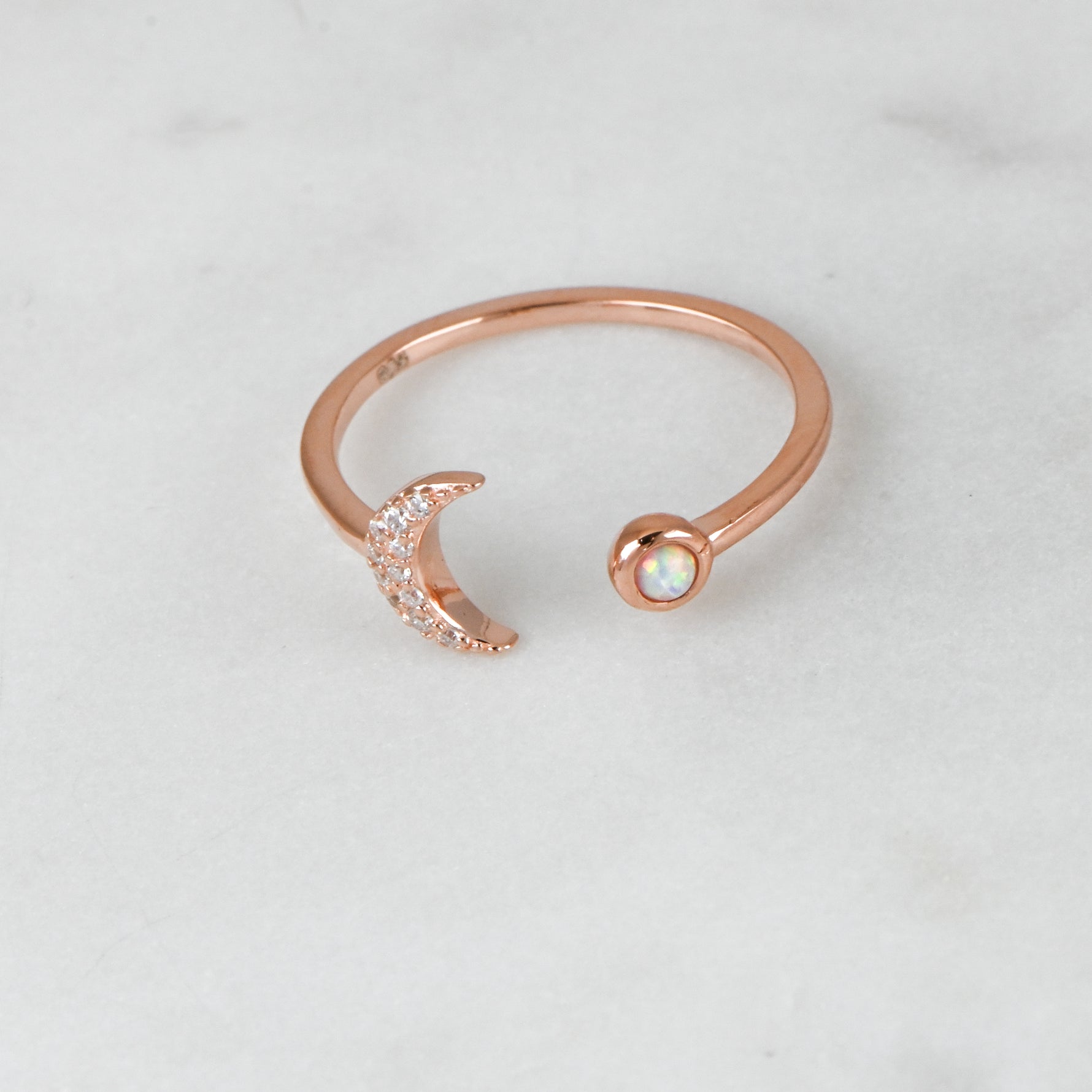 Upclose shot of rosegold opal and cz adjustable moon ring.