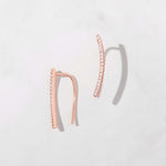 Rose gold ear climber with cz studs on white background.