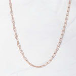 Delicate rose gold paperclip chain necklace on marble background