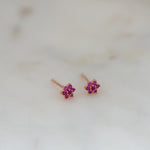 Upclose shot of ruby rosegold floral stud earrings. 