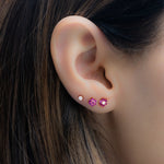 Model wearing ruby gemstone floral earring stack.