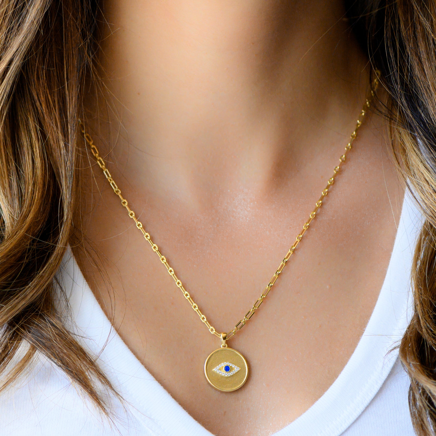 Model wearing circle medallion pendant necklace. 