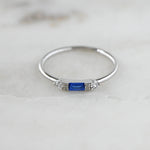 Sterling silver dainty sapphire baguette thin ring in soft studio lighting. 