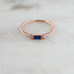 Dainty rosegold birthstone sapphire ring on marble background. 