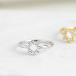 Feminine silver cz sun solitaire ring in soft studio lighting. 