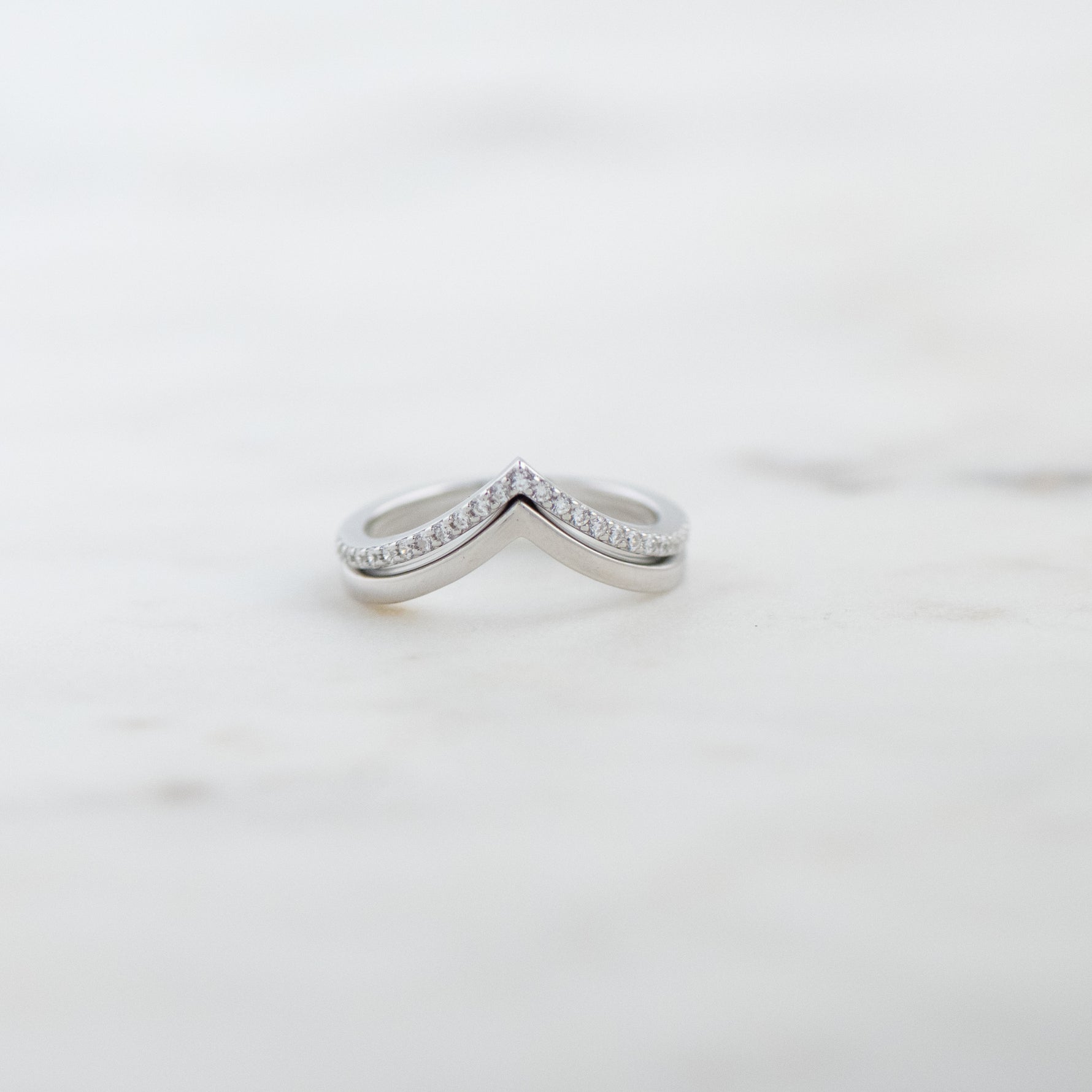 Upclose image of sterling silver chevron ring set with one pavé band and one plain band