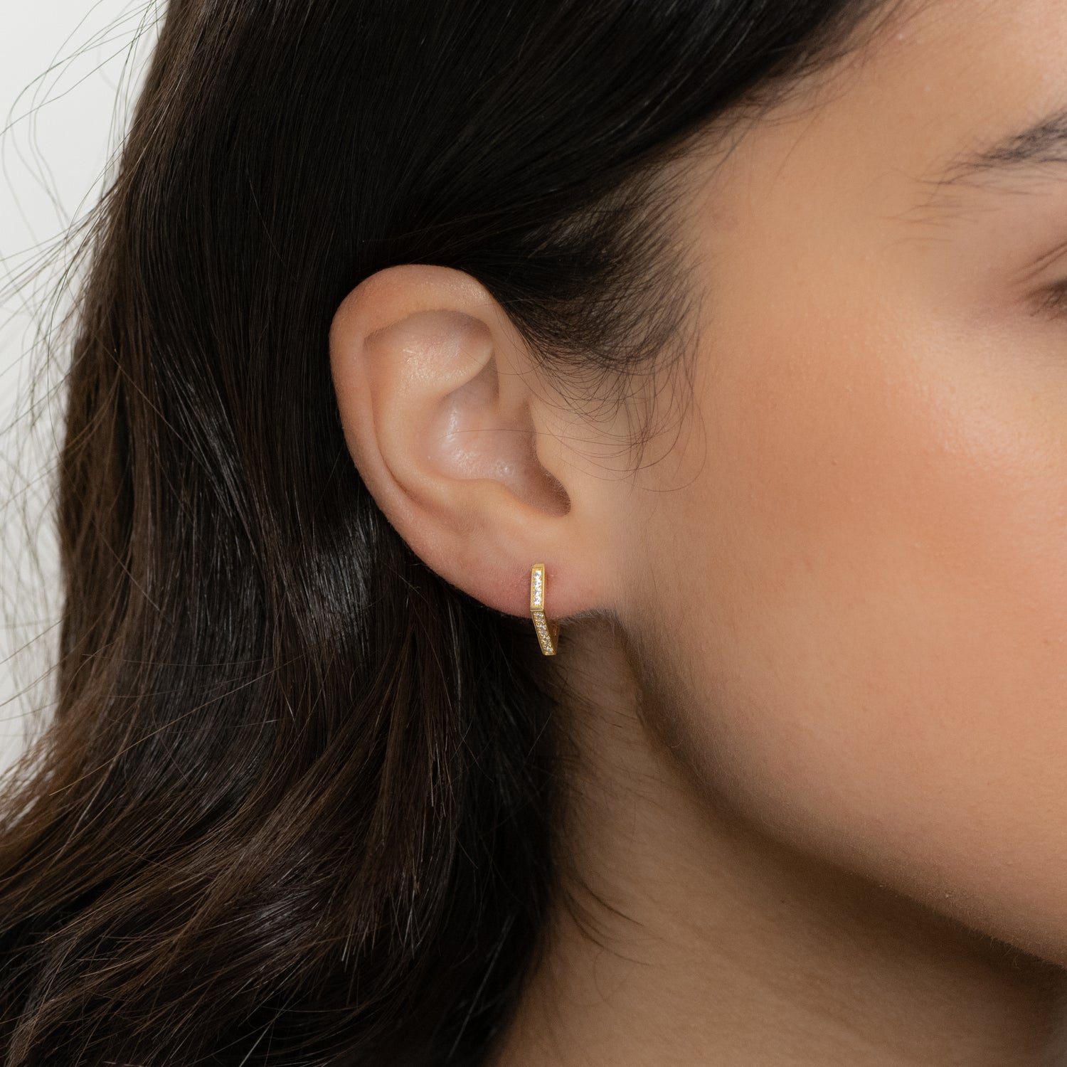 Small geometric diamond huggie earrings from Sami Jewels, showcasing sleek silver hoops with a modern design.