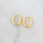 Small gold huggie hoops with an oval shape
