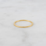 Upclose image of dainty gold plain band.