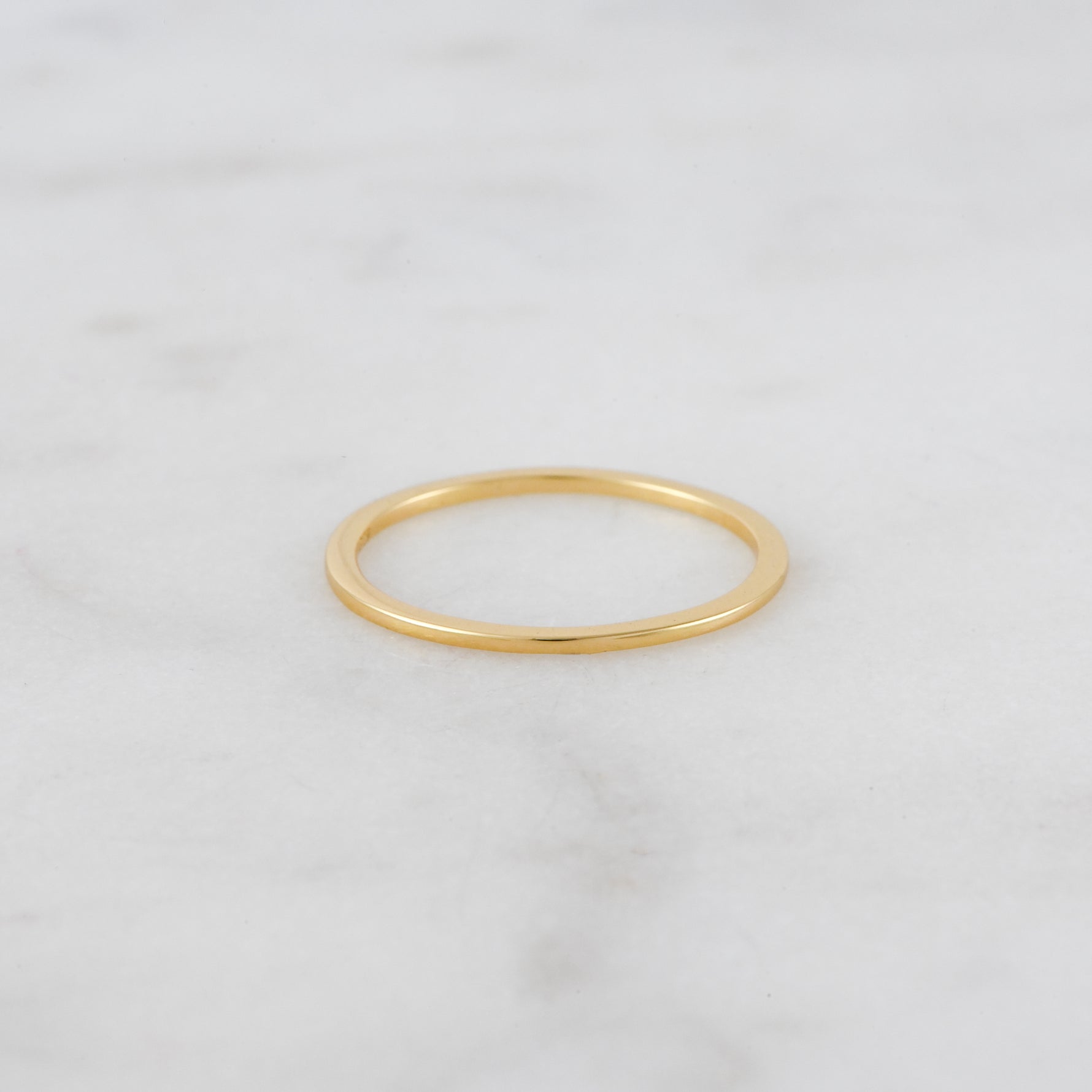 Upclose image of dainty gold plain band.