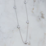 Dainty sterling silver plain star collar necklace on marble background.