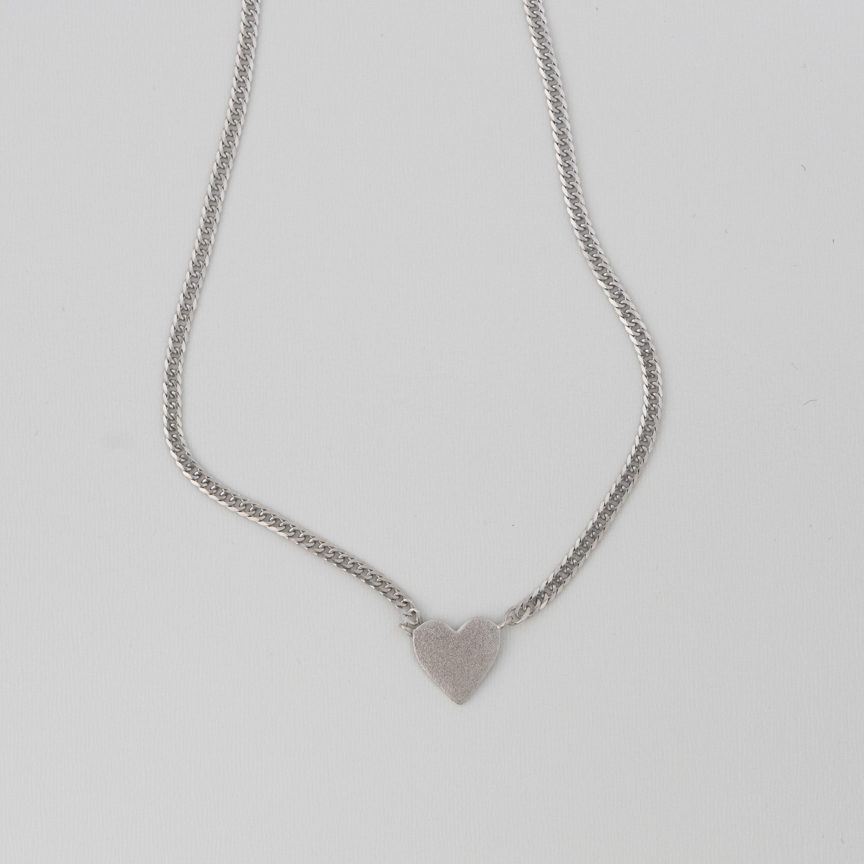 Sterling silver heart pendant necklace with curb link chain.